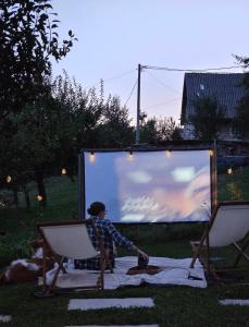 a woman sitting in a chair in front of a screen at Javor Holiday House in Žumberak