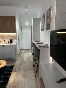 a kitchen with white cabinets and a counter with stools at Tsimiski Central Suites in Thessaloniki
