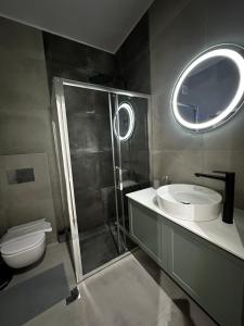 a bathroom with a shower and a toilet and a sink at Tsimiski Central Suites in Thessaloniki