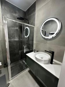 a bathroom with a sink and a shower and a mirror at Tsimiski Central Suites in Thessaloniki +37 photos