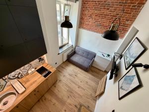 a bathroom with a sink and a couch in a room at Apartments Piotrkowska 67 in Łódź