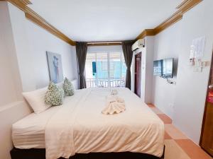 a bedroom with a large bed with a doll on it at Aura Hotel Phi Phi in Phi Phi Islands +200 photos