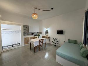 a living room with a bed and a table and a kitchen at Taxiarchis in Symi
