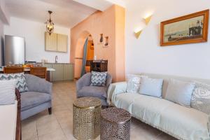 a living room with a couch and two chairs and a kitchen at Alma Libre Villas in Kastraki