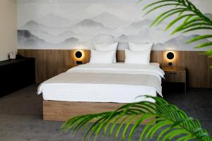 a bedroom with a bed with a mountain mural on the wall at Altay Resort in Shchūchīnsk +67 photos