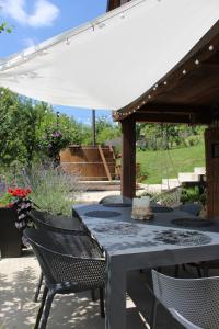 a table and chairs under an umbrella on a patio at Javor Holiday House in Žumberak