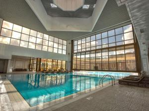 a large swimming pool in a large building at Sofitel Algiers Hamma Garden in Alger