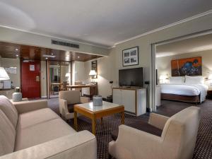 a hotel room with a bed and a living room at Sofitel Algiers Hamma Garden in Alger