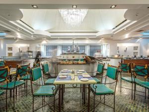 a restaurant with a table and chairs in a room at Sofitel Algiers Hamma Garden in Alger