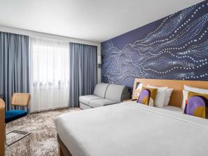 a hotel room with a bed and a couch at Novotel Paris Charenton le Pont in Charenton-le-Pont +125 photos
