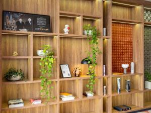 a wooden book shelf with plants and books at Hotel Mercure Wien City in Vienna