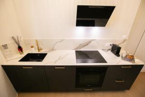 a kitchen with a black and white counter top at Maison Lumière Arras in Arras +27 photos