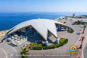 a domed building with the ocean in the background at The Terraces Seafront Getaway Malta 3 Bedroom Apartment in St. Paul's Bay