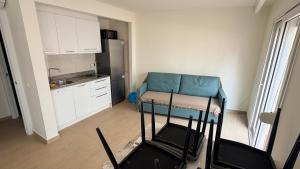 a living room with a blue couch and a kitchen at Apartamentos Lin in Lloret de Mar