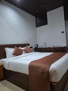 a bedroom with a large bed with brown and white pillows at Merjin's Paraiso in Vagamon +2 photos