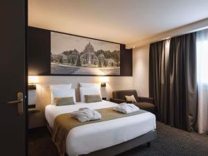 a hotel room with a large bed and a chair at Hôtel Mercure Lyon Centre Charpennes Parc de la Tête d'Or in Villeurbanne +88 photos