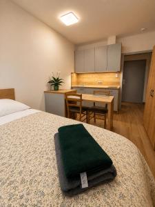 a bedroom with a bed with a green towel on it at Microbyty & Apartments in Děčín