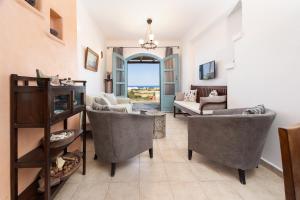 a living room with two chairs and a couch at Alma Libre Villas in Kastraki