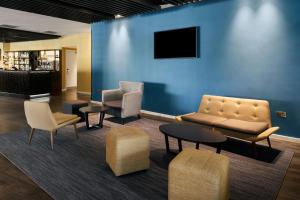 a waiting room with chairs and tables and a blue wall at Four Points Flex by Sheraton Dundee in Dundee