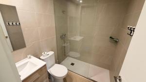a bathroom with a toilet and a sink and a shower at Apartamentos Lin in Lloret de Mar