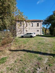 a car parked in a yard in front of a building at Orchard House South Room in Pergola