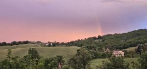 a rainbow in the sky over a green field at Orchard House South Room in Pergola