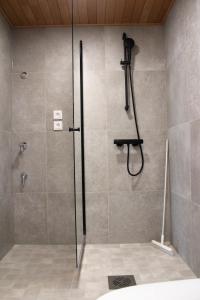 a shower with a glass door in a bathroom at Spot Apartments Airport Premium in Vantaa