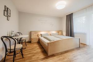 a bedroom with a bed and a table and chairs at Chambtaler Hof in Runding