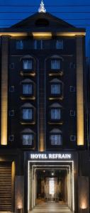 czarny budynek z tabliczką polecającą hotel w obiekcie HOTEL REFRAIN w Tokio