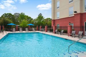 a swimming pool at a hotel with chairs and umbrellas at Hampton Inn Thomson in Thomson