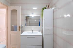 a white bathroom with a sink and a mirror at Casa Cabana in El Médano