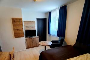 a room with a bed and a table and a television at 'Schlabecks - Fränkischer Hof' - - - Garni-Hotel-Pegnitz in Pegnitz