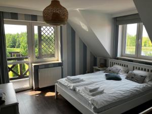 a bedroom with a bed in a room with windows at Dom Nowe Krzywe in Nowe Krzywe