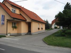 una casa con techo rojo en una calle en Apartmaji in sobe RaMar en Straža