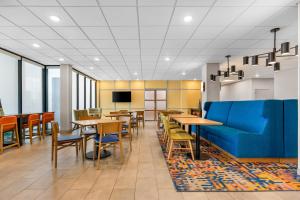 a restaurant with tables and chairs and a blue couch at Hampton Inn Chicago-Gurnee in Gurnee