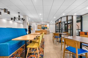 a restaurant with tables and chairs and a blue couch at Hampton Inn Chicago-Gurnee in Gurnee