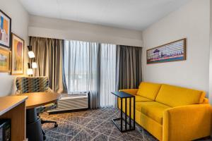 a hotel room with a yellow couch and a table at Hampton Inn Chicago-Gurnee in Gurnee