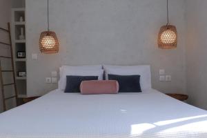 a bed with two pendant lights and a purse on it at BOĒM Boutique Hotel Lefkada in Lefkada