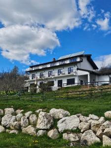 a large white building on a hill with rocks at Belvedere Chalet Bran in Bran