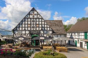 a building with tables and umbrellas in front of it at Xavers Ranch in Meschede