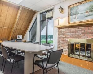 a conference room with a table and chairs and a fireplace at Rodeway Inn in Grand Falls