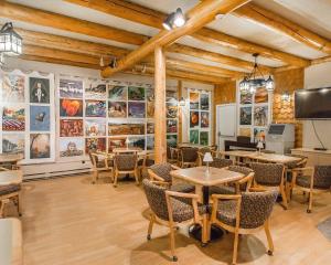 a restaurant with tables and chairs and paintings on the walls at Rodeway Inn in Grand Falls