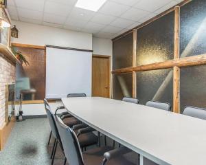 a conference room with a table and chairs and a whiteboard at Rodeway Inn in Grand Falls