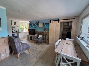 a living room with a table and chairs and a kitchen at Domki Spore in Spore