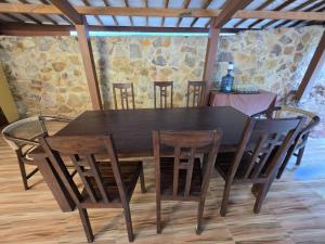 a dining room table and chairs with a stone wall at Popeye Karimunjawa in Karimunjawa +16 photos