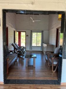 a living room with chairs and a table in a room at Nature's Abode in Pune