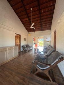 a living room with chairs and a ceiling fan at Nature's Abode in Pune