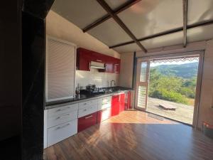 a kitchen with red cabinets and a large window at Nature's Abode in Pune +10 photos