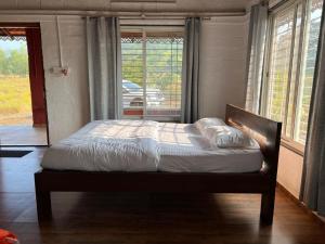 a bed sitting in a bedroom with a window at Nature's Abode in Pune