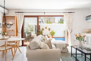 a living room with a white couch and a table at Casa Pueblo Lopez in Fuengirola